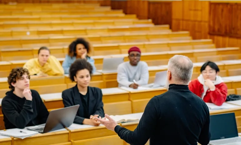 Professor lecturing a diverse group of students in a university lecture hall