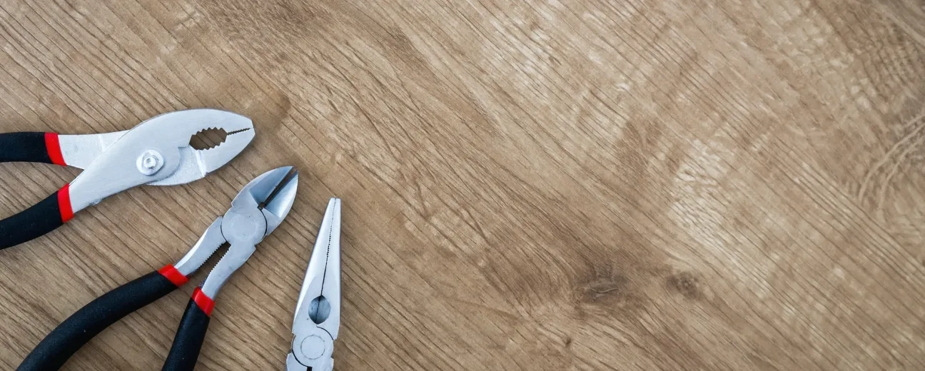 three pliers on wood surface