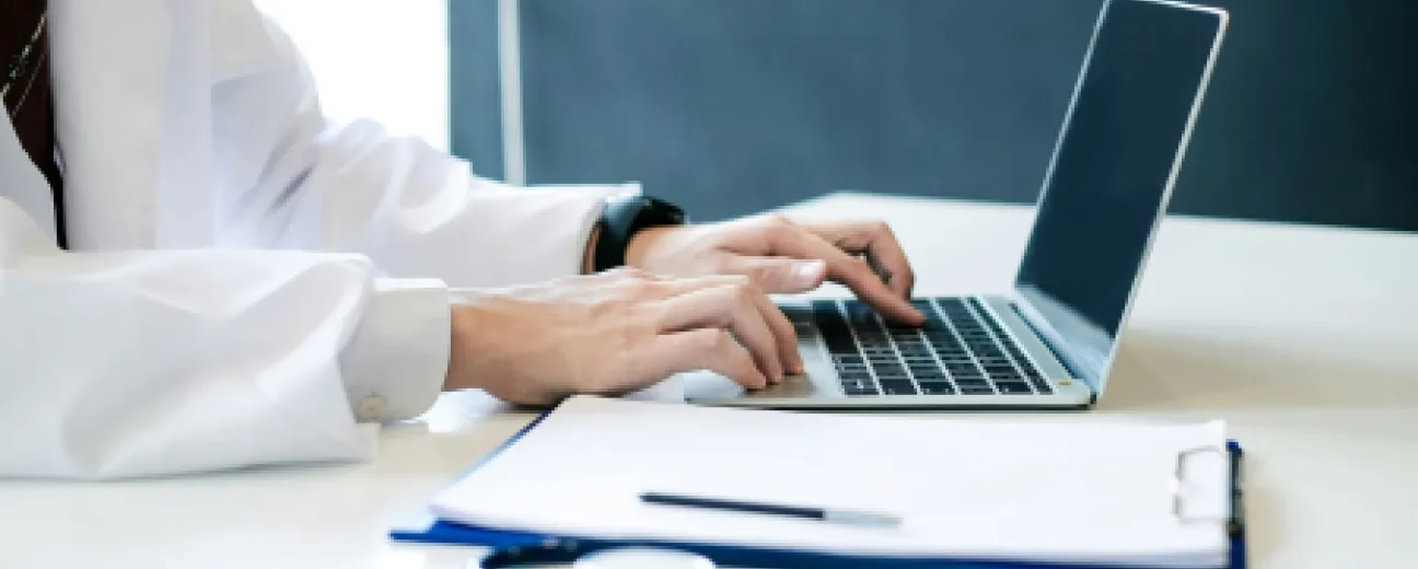 Doctor typing on a laptop