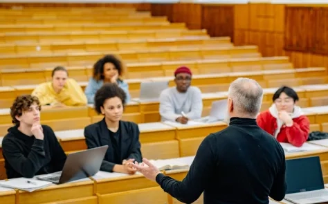 Professor lecturing a diverse group of students in a university lecture hall