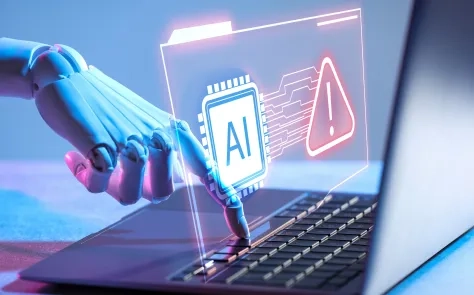 Robotic hand typing on a laptop with a glowing AI chip and warning sign hologram illustrating cybersecurity threats