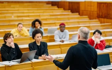 Professor lecturing a diverse group of students in a university lecture hall